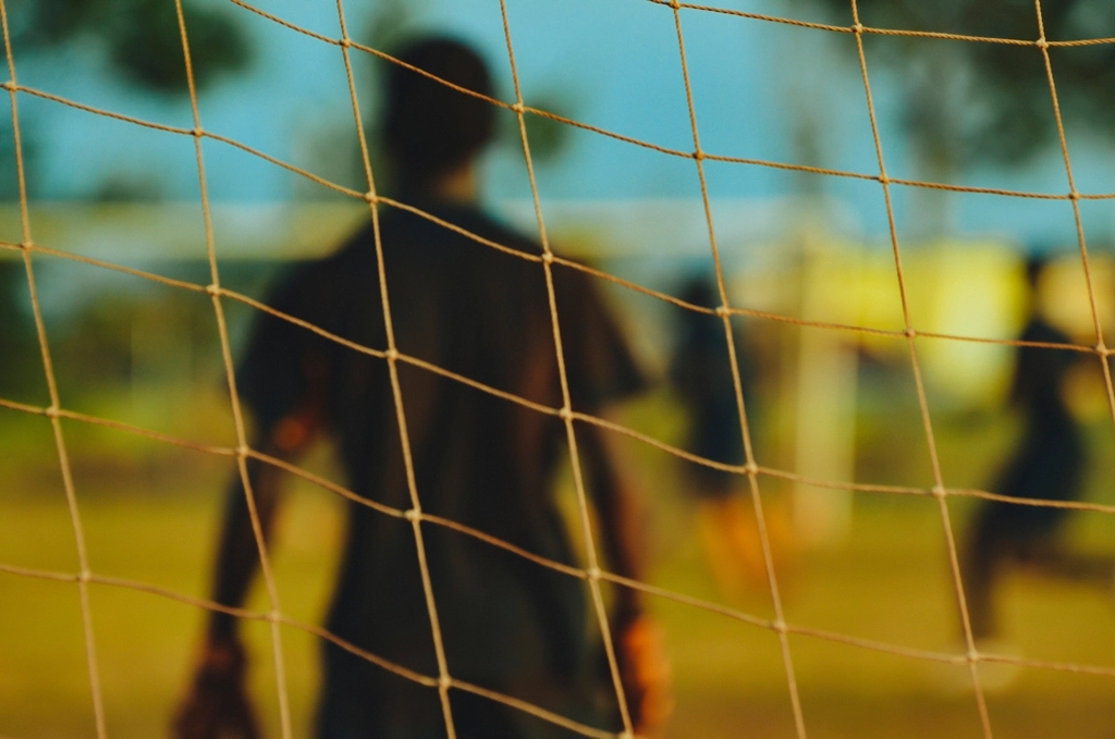 Blurred goalkeeper focused goal net